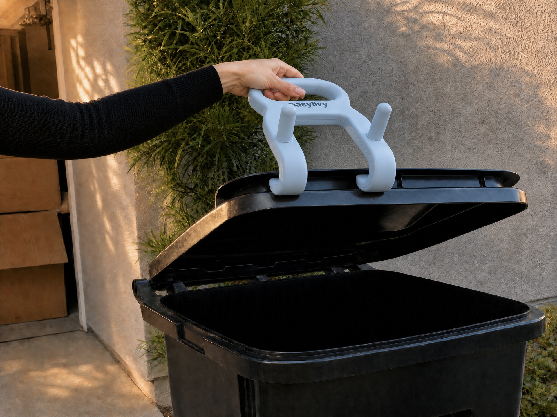 The Easylivy Curbside Bin Handle's tapered front hook lifting the trash bin lid without touching it by hand.